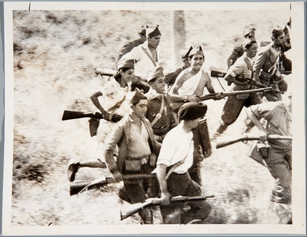 Espanjan sisällissodan alkuvaiheesta, vuodelta 1936 olevassa kuvassa tasavaltalaiset miliisit ovat hyökkäämässä vihollisen kimppuun. Katsojaa hämmästyttävät iloiset ilmeet. Kertovatko ne kuvan lavastamisesta, mikä oli sotakuvissa yleistä, vai olivatko mielialat sodan alkuvaiheessa todella näin optimiset. Mukana näkyy olevan myös naispuolinen miliisi. Lähde: Google Art Project.
