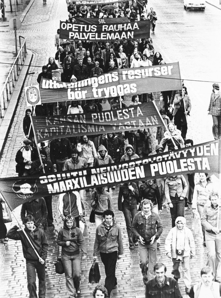 Kansan puolesta kapitalismia vastaan. Taistolaisia iskulauseita ja mielenosoittajia Helsingissä 28.4.1977. Lähde: Kansan Arkisto